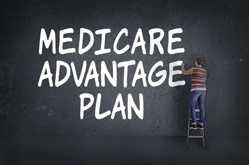 animation of a person on a ladder writing Medicare Advantage Plan on a large chalkboard